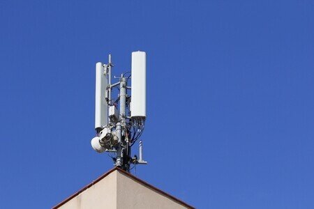 71044751-青い空を背景に、建物の屋根に携帯電話アンテナ