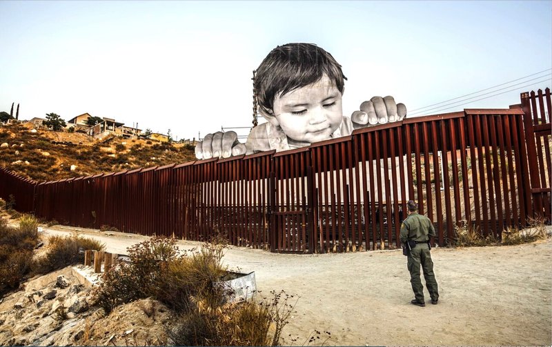  アメリカの国境を覗くメキシコ人の子ども