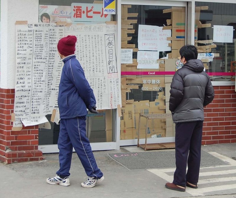 ３月15日午後　トリミング石巻日日新聞号外の壁新聞を見る人たち