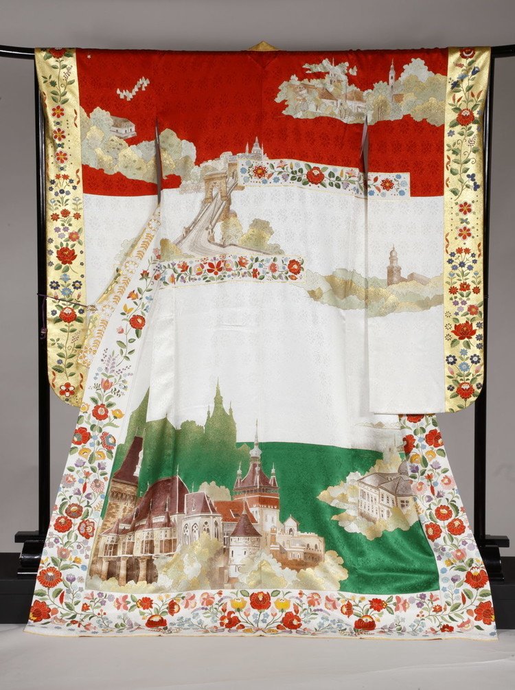 ハンガリー国旗の赤・白・緑の三色で全体を構成し、ヴァイダフニャド城や国会議事堂、アンドラーシ通り、ドナウ沿岸の風景などが描かれています。 冬になるとヴァイダフニャド城のお堀の一部はアイススケートのリンクとなるそうですよ。 愛らしい花文様の額縁取りが可愛らしいKIMONOです。