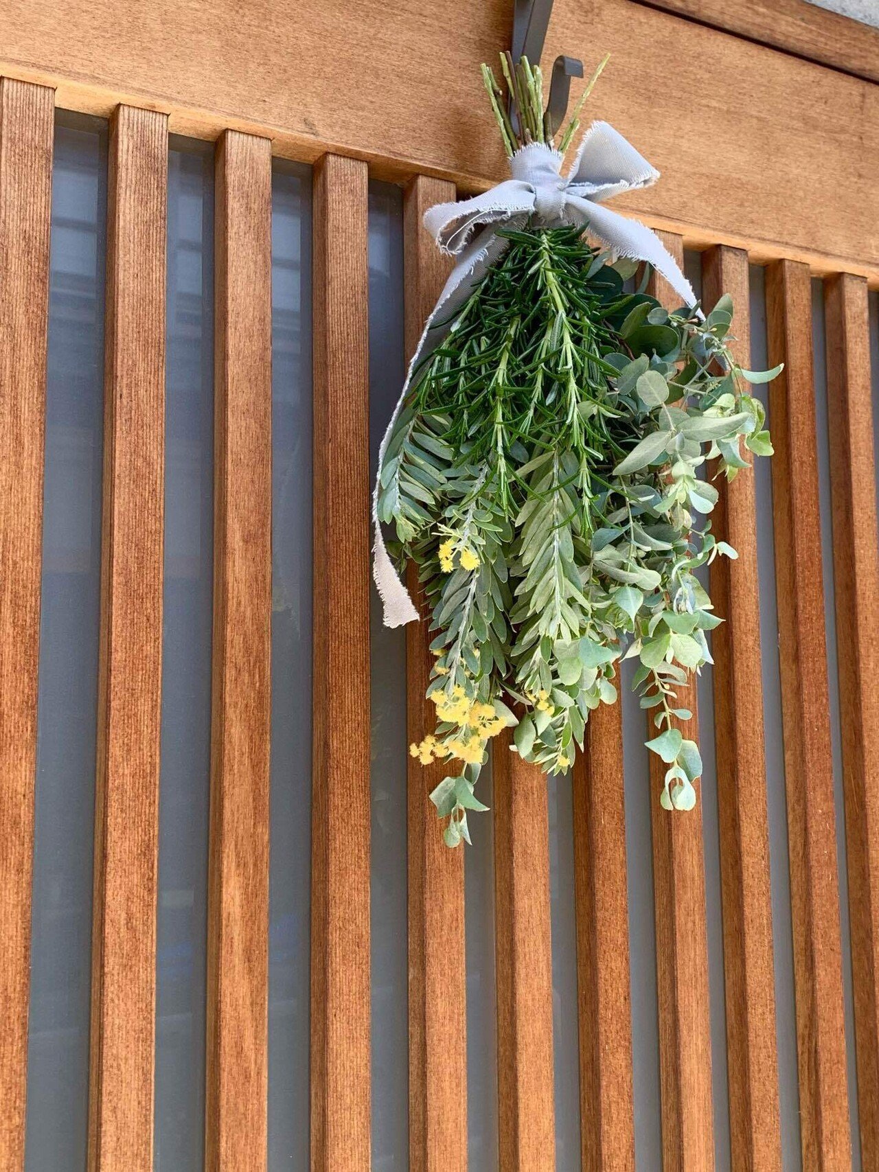 お庭に咲く ローズマリー ミモザ ユーカリ を束ねたスワッグ 今からの時期植木を一度カットしてあげると新しい芽がどんどん出てくれますよ 少し残ってるミモザの黄色がいい感じ 玄関にローズ Atelier月陽 Note