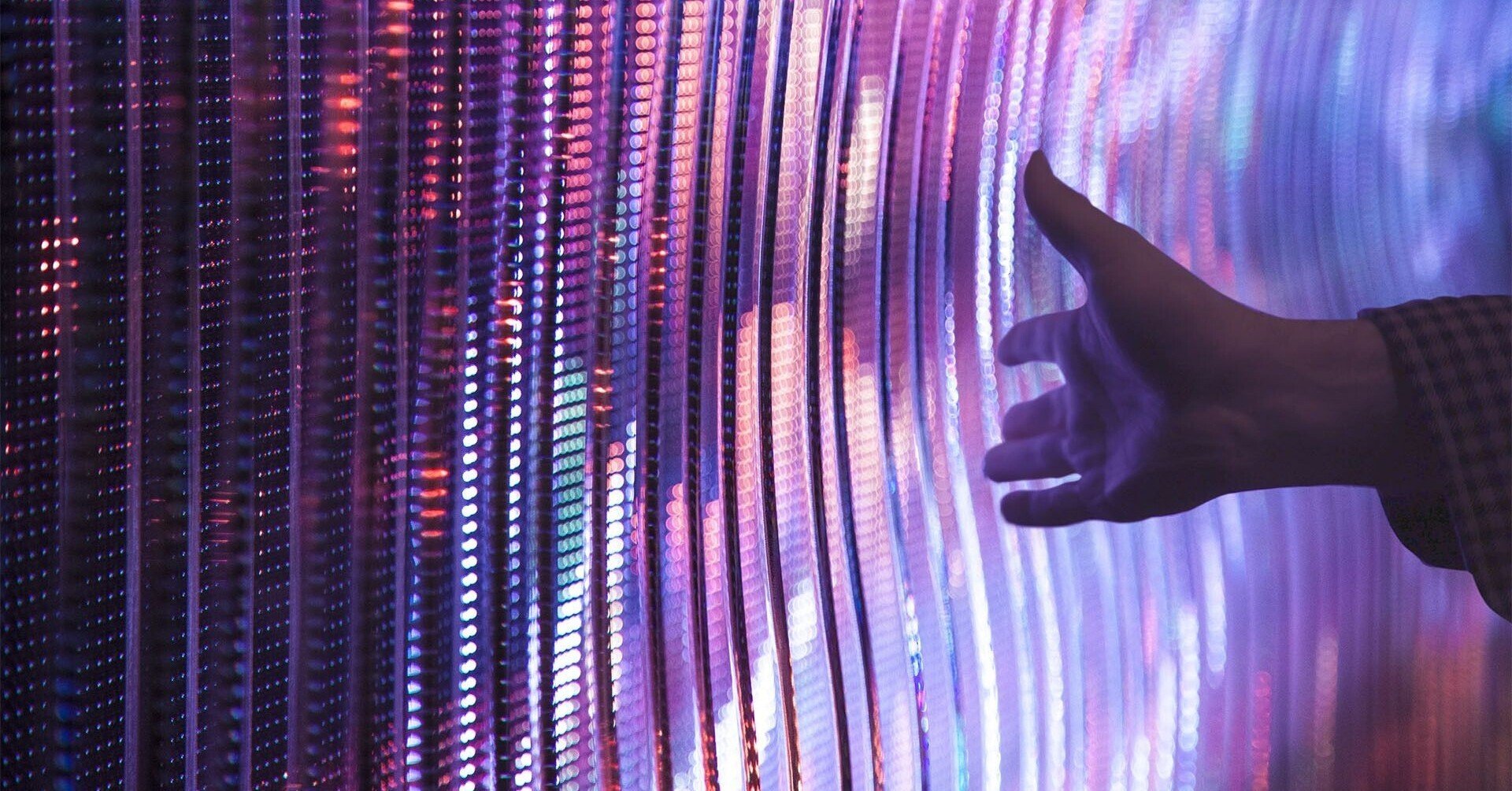A hand waving over purplish digital lights