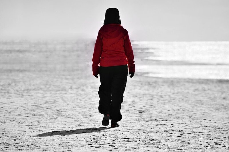 女性・歩く・砂浜・赤い上着