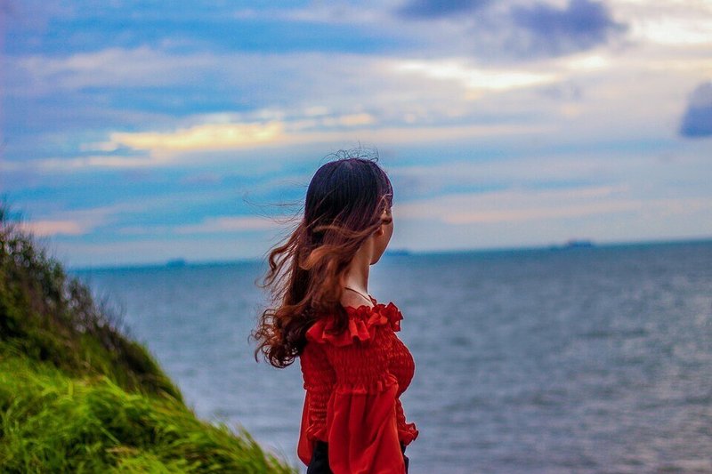 女性・水平線・海を眺める・後ろ姿・風になびく髪