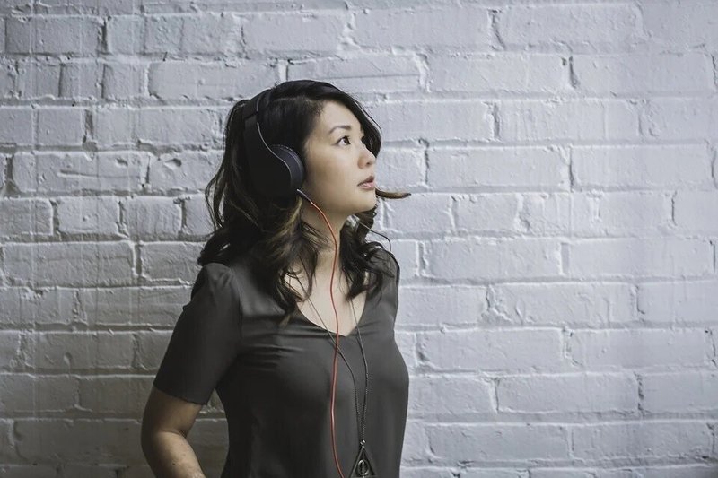 女性・ヘッドフォン・音楽・聴く・アジア系・壁・見上げる