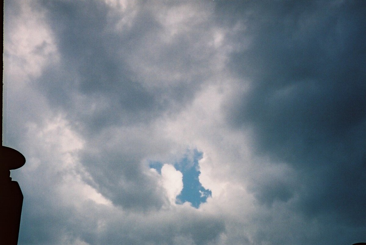 雲間から見える空のフィルム写真。