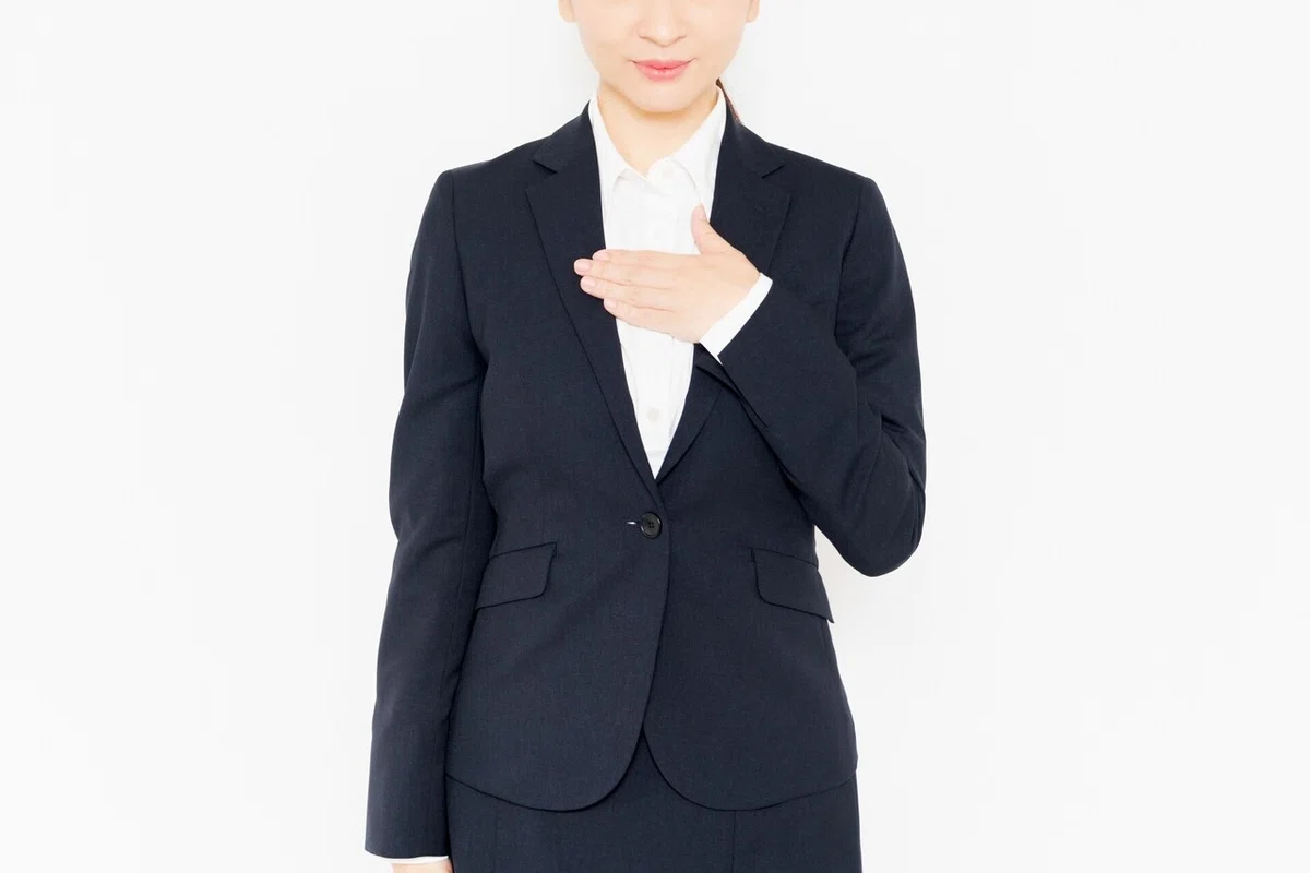 胸に手を当てる女性