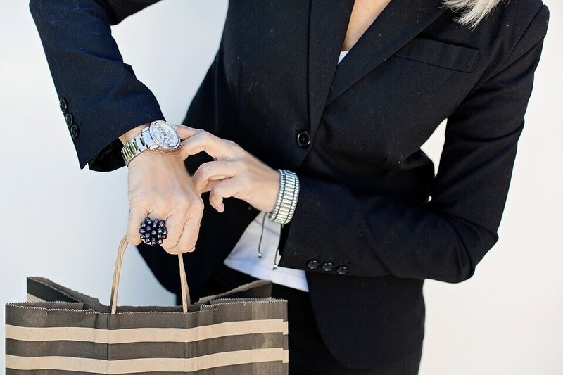 女性・時間・追われる・スーツ・時計をチェック・紙袋・ビジネス