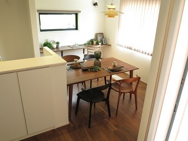 LDKがL字型でキッチンがその中央に設置された間取りの家具の配置術28