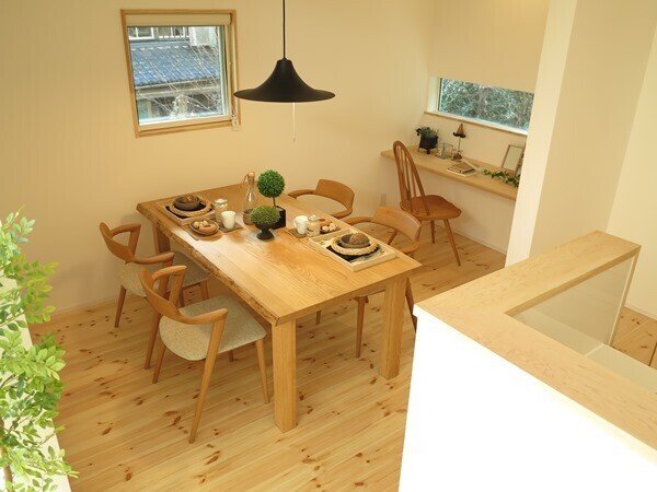 LDKがL字型でキッチンがその中央に設置された間取りの家具の配置術01