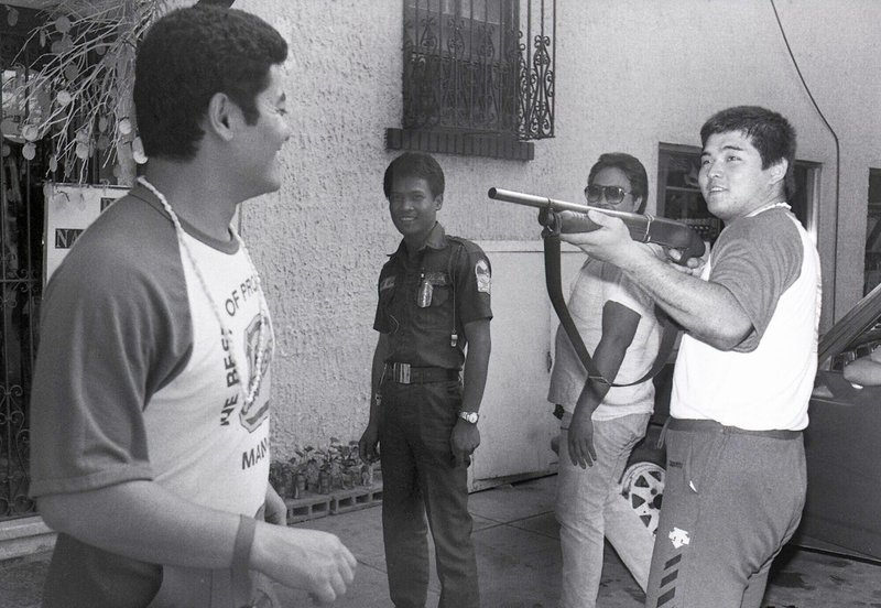 警備員に借りた銃で後藤達俊（左）を狙う橋本真也（８４年１２月、フィリピン・マニラ市内）