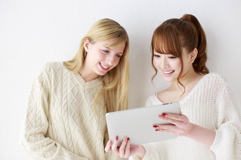 タブレットPCの画面を見る二人の女性
