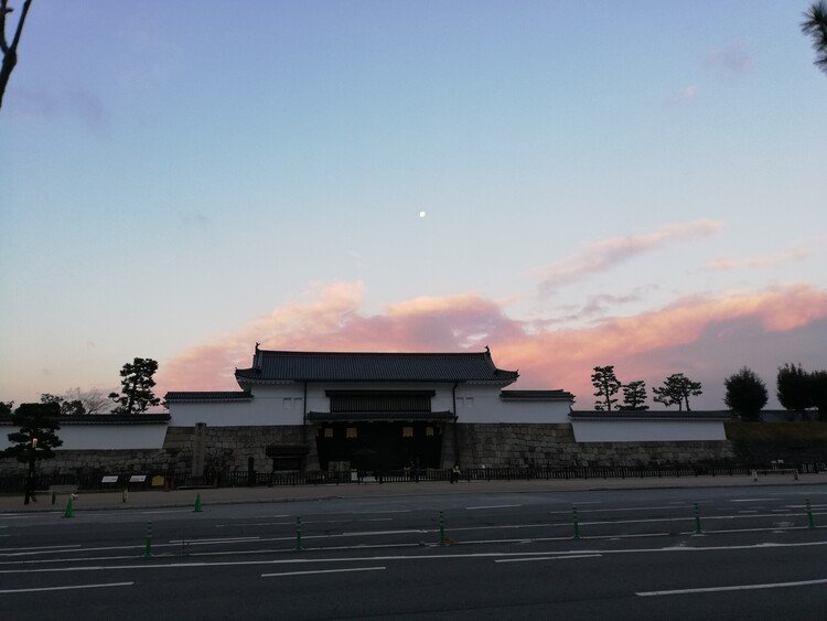 朝の二条城。朝陽に照らされる雲。その上に浮かぶ月。今日もまた1日が始まる。