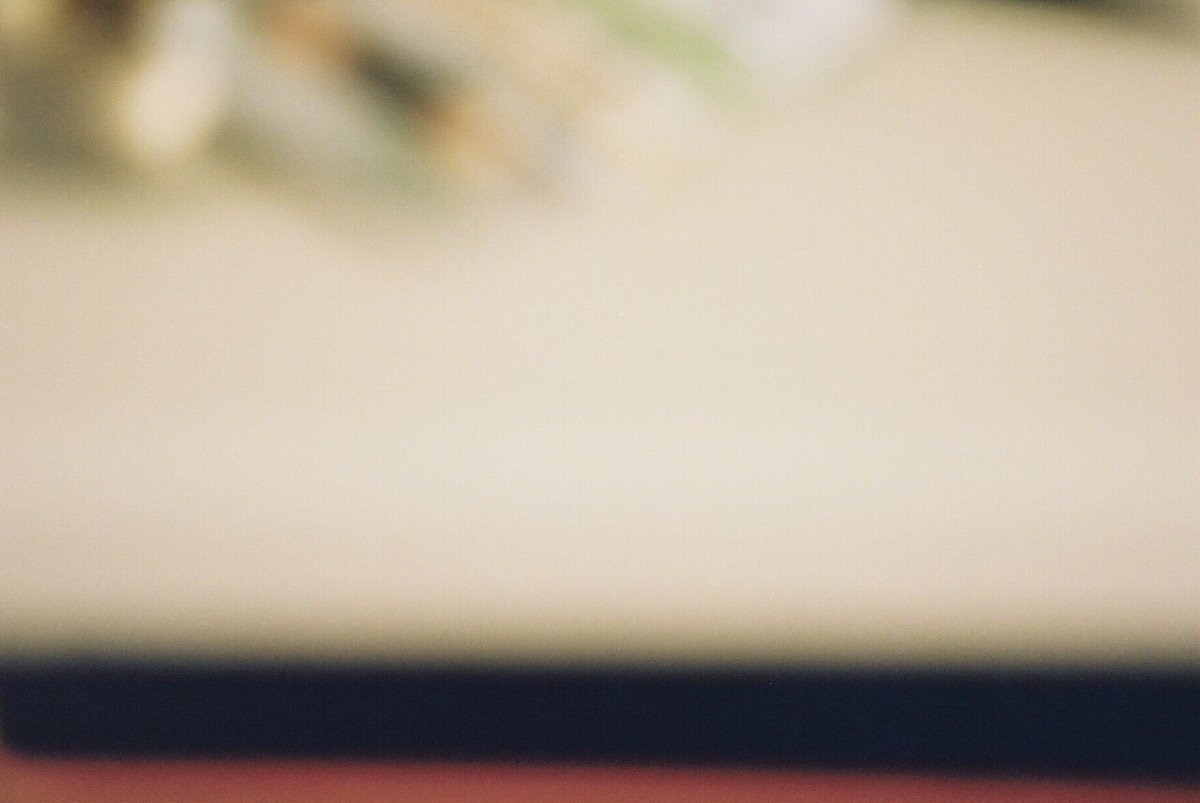 デスク周りのフィルム写真。だがぶれまくっていてなにが写っているのかはわからない。