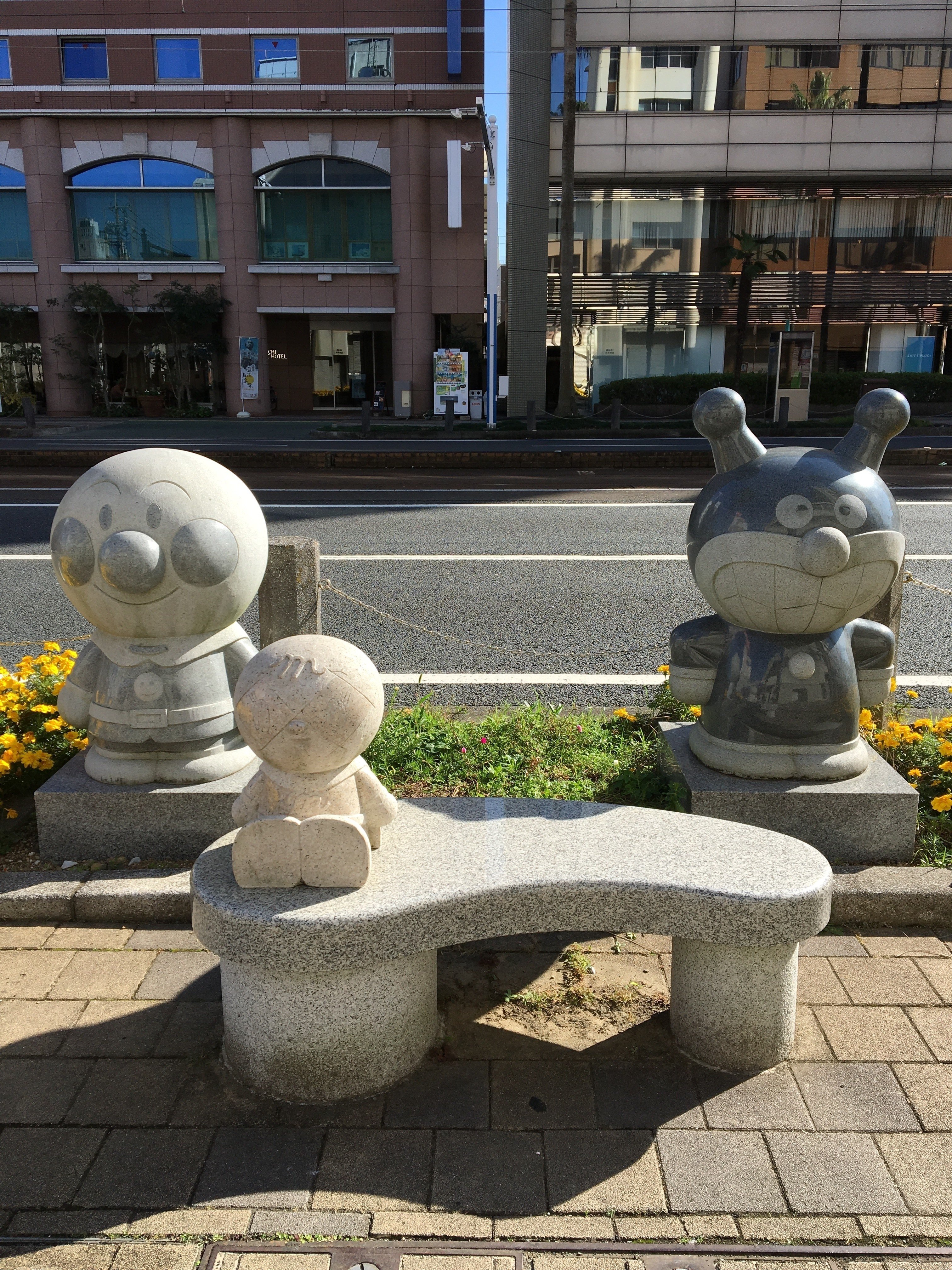 高知駅と、駅から少し歩いた道沿いに アンパンマンのキャラクターの