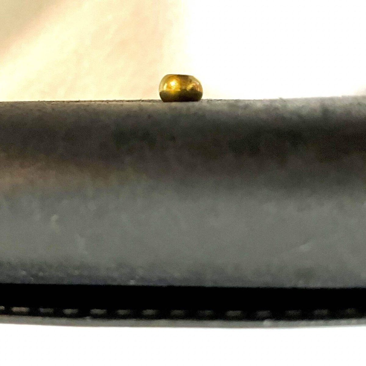 長財布についたホックを真横から見たところ。横幅の半分くらいの厚みがあることがわかる。